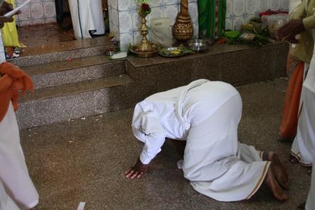 Man prays in temple after paying a coin